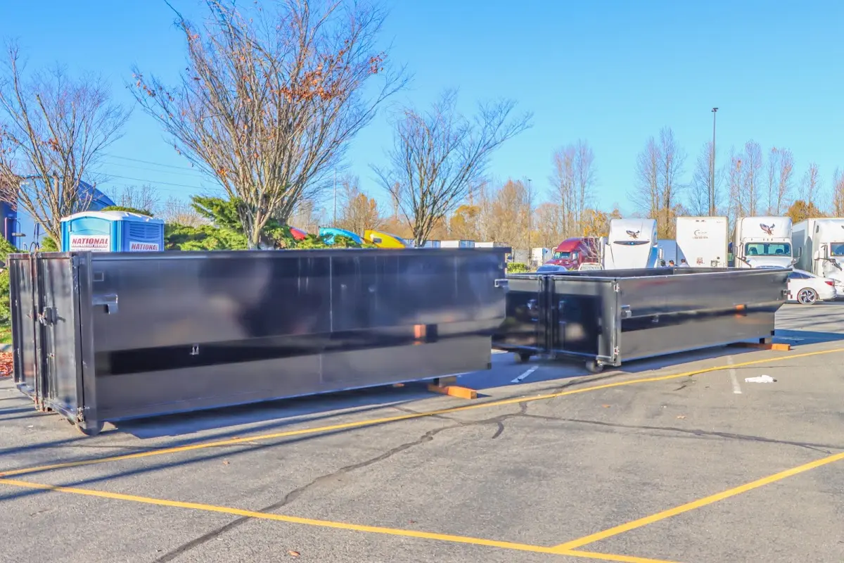 Professional dumpster rental service with roll-off container on residential driveway in Framingham
